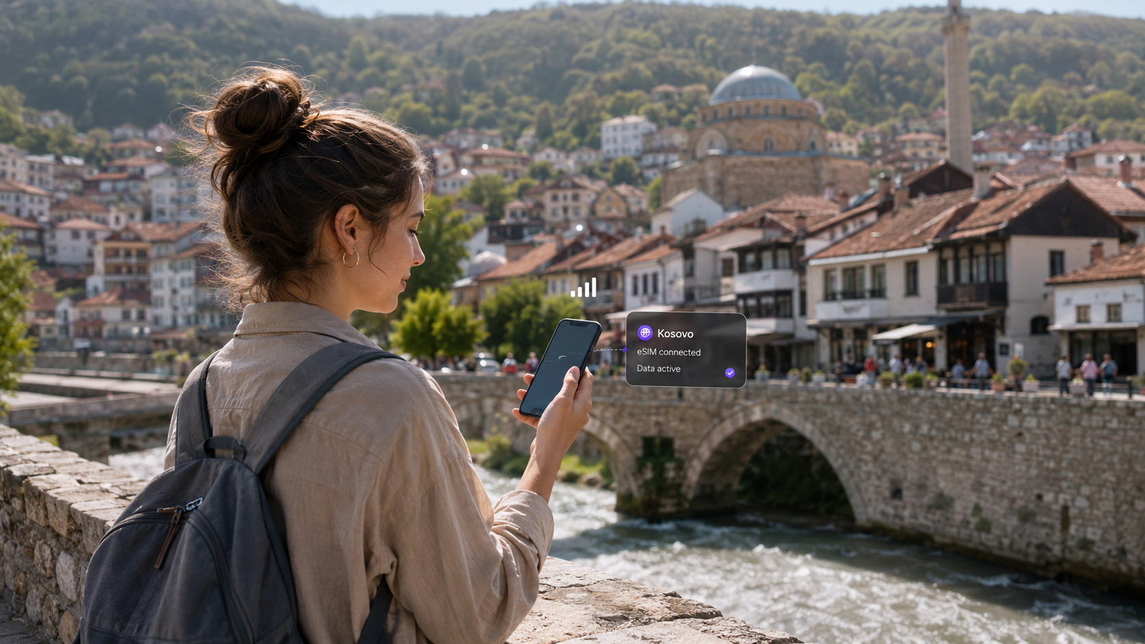 Traveler using a smartphone with a Kosovo eSIM for mobile data in Prizren