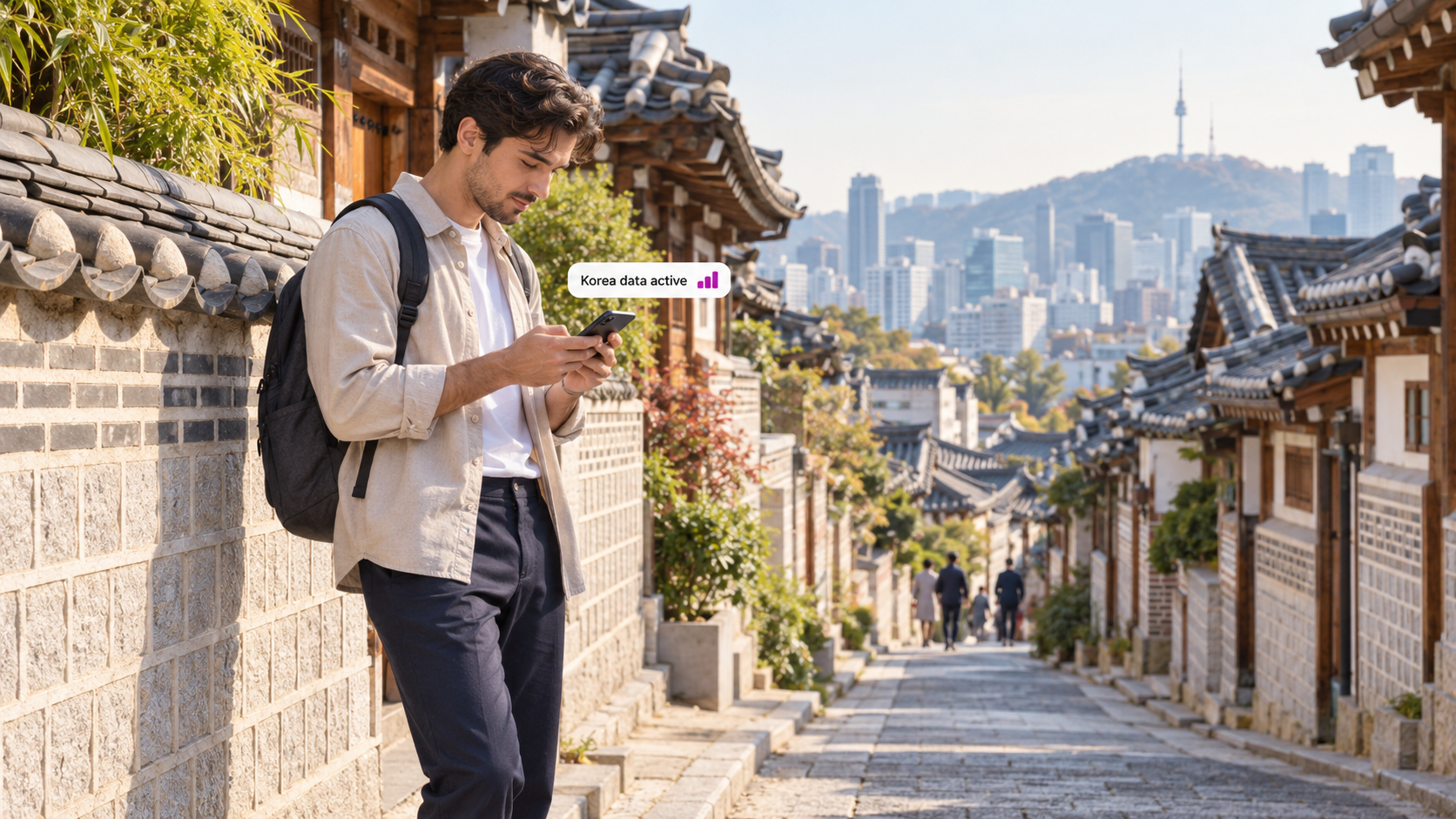 A traveler uses a smartphone in Seoul’s Bukchon Hanok Village, surrounded by traditional Korean architecture and city views, illustrating easy mobile connectivity with a duasim travel eSIM in South Korea.